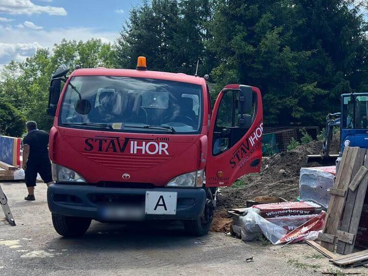 Červený nákladní vůz s logem STAVIHOR na staveništi